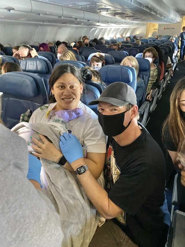 Lavinia Mounga and Dr. Dale Glenn posing after Mounga's gave birth aboard a Delta flight to Hawaii