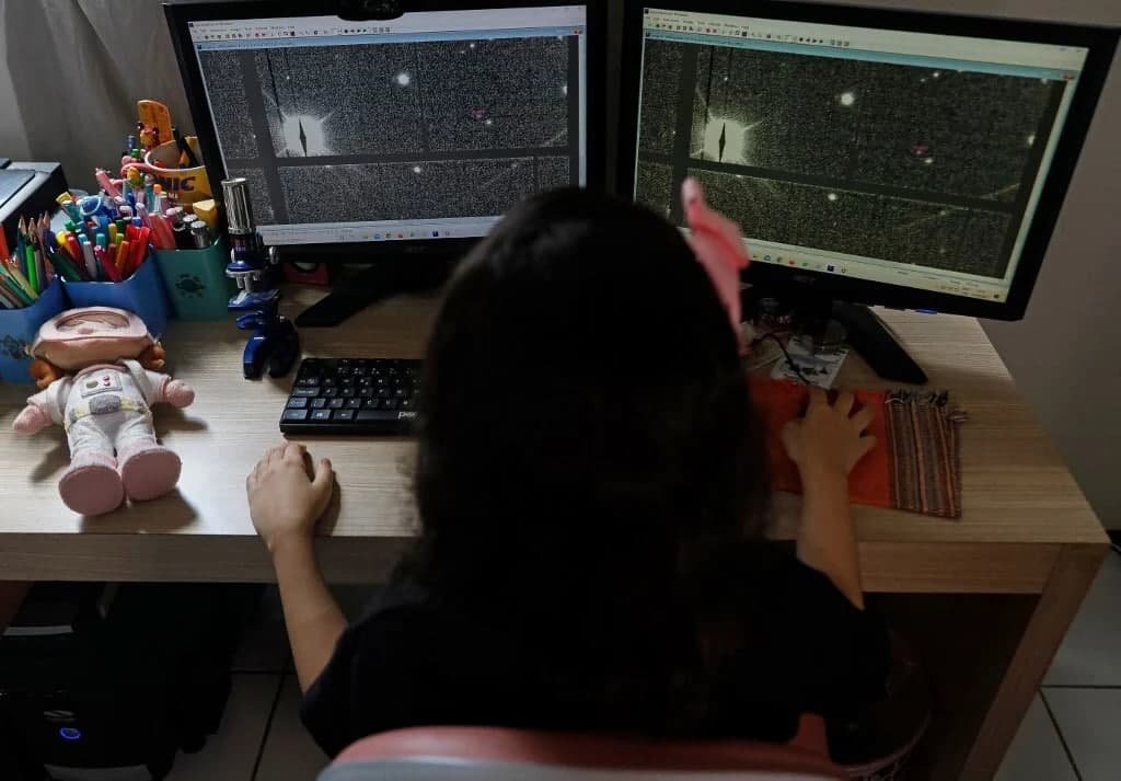 Nicole Oliveira works on her computer at her house in Fortaleza